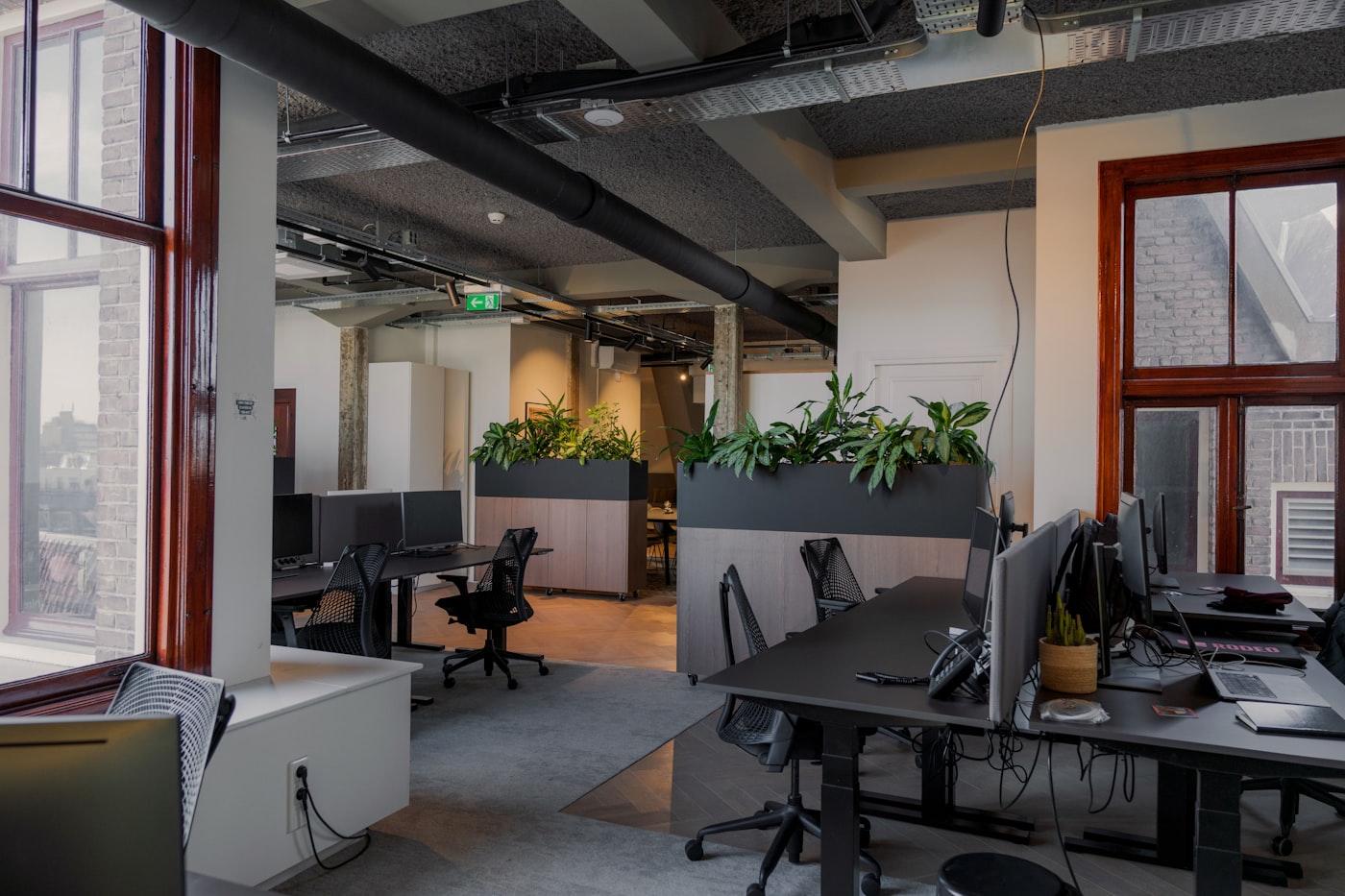 An open-plan office full of desks, chairs and monitors