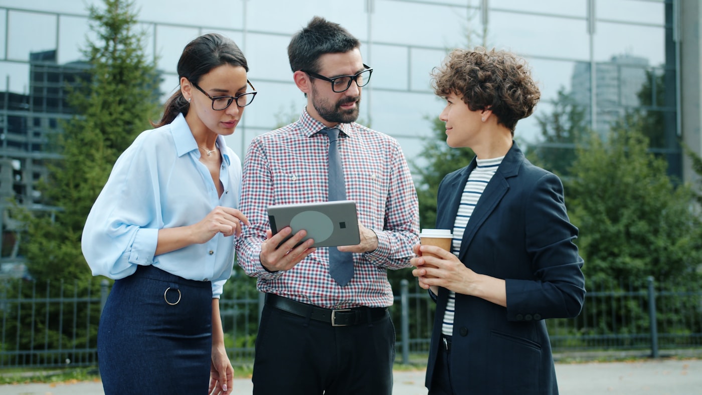 A field team reviewing a tablet outdoors
