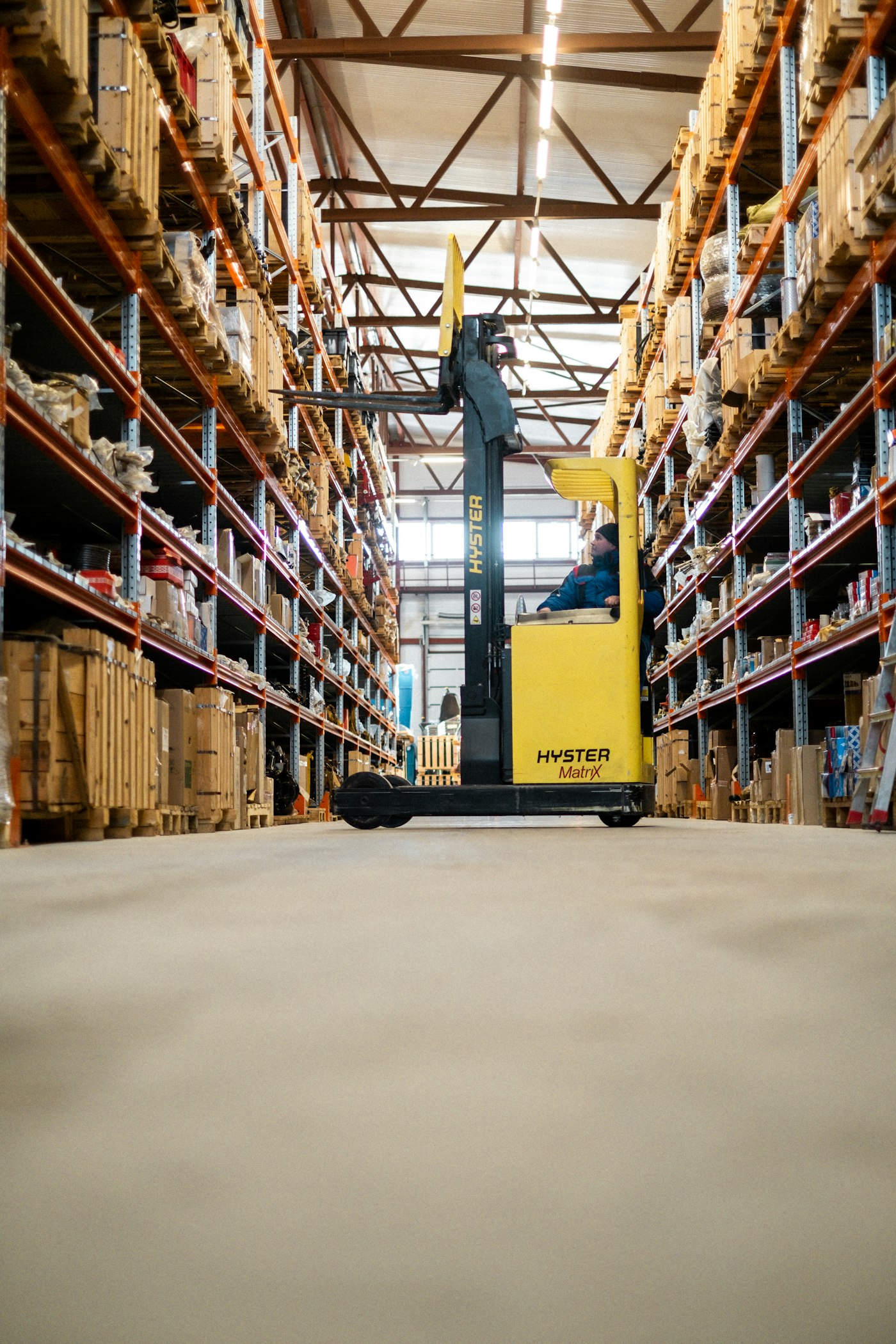 A worker moving inventory in a warehouse aisle